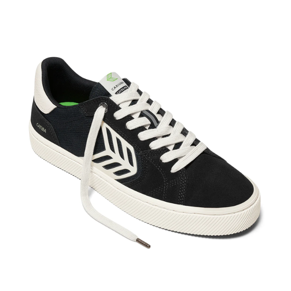 Black and white sneaker with a visible brand logo on a white background